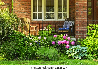 Front Of Home With Chairs And Flower Garden