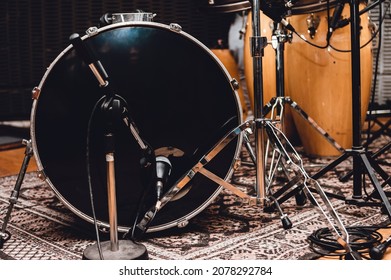 Front And Horizontal View Of A Black Bass Drum With Professional Recording Microphones And Other Latin Percussion Instruments, In A Music Studio.