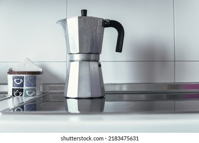 Front Image Of A Gray Metal Coffee Pot On Top Of A Glass Ceramic Stove That Has Just Made Coffee For Breakfast. Concept Of Freshly Prepared Breakfast.