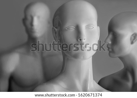 front image of shiny white female mannequin doll with a male mannequin figure in the back, on black and white background. front image of a display dummy figures