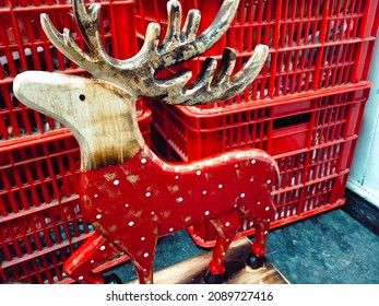 The front left side view of the red  wooden reindeer is standing on the black valley