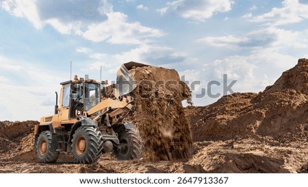 Front loader or bulldozer digs and moves soil on a construction site. Earthworks. Construction equipment rental.