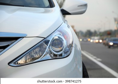 Front look headlamp white car on the roadside