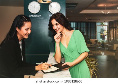 Front Office Staff Serving Guests In The Hotel Concept : Asian Female Staff Greeted The Female Tourists At The Counter With A Smile, Giving Good Service Advice And A Friendly Welcome In The Hotel.