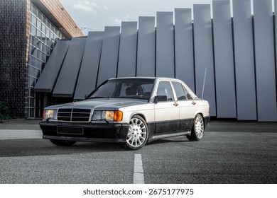 Front offset view of a German two tone zilver and black classic car with long antenna at a beautiful photo location