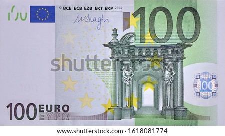 Front part of 100 euro banknote close-up with small green details. European currency bill
