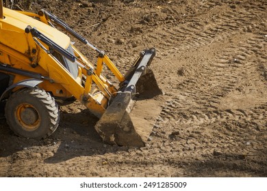 Front part of yellow bulldozer with bucket on construction site, bulldozer operation on a dirt site