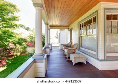 Front porch with chairs and columns of craftsman style home.
