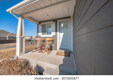 Front Porch Exterior With Two Wooden Rocking Chairs Against The Window With Fake Shutters Design