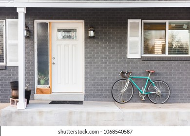 Front Porch Of Grey Gray Brick House With Parked Bike