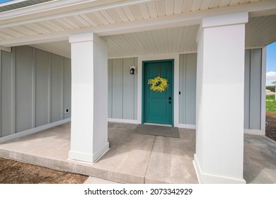 Front Porch Of A House With Blue Green Front Door And Yellow Wreath