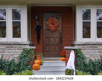 Front Porch Of House With Halloween Decorations And Wreath On Wooden Front Door