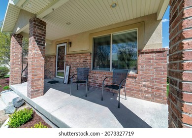 Front Porch Of A House With Two Chairs And Signboard Near The Front Door