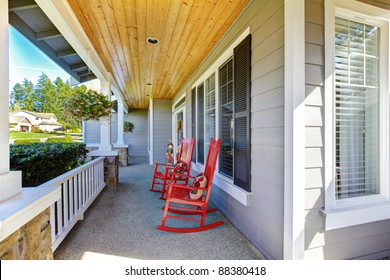 Front Porch With Two Red Chairs And Railing