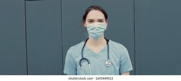 FRONT Portrait of tired nurse or doctor wearing medical mask looking into camera. COVID-19, Coronavirus pandemic - Shutterstock ID 1693449013