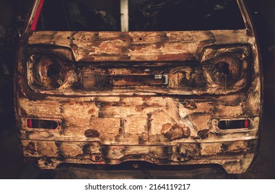 Front Of An Rusty Car In Garage