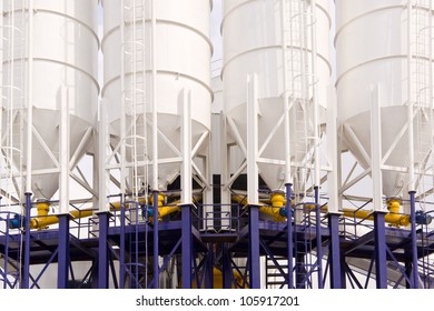 Front Shot Of Four Industrial Chemical Processing Tanks.