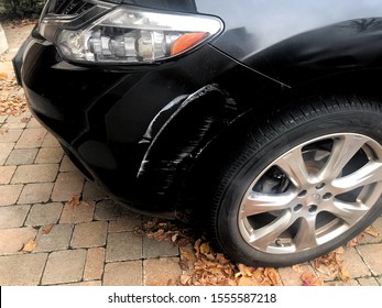 Front side of black car with white scrape. 
