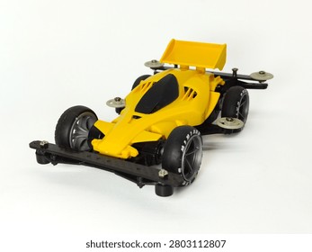 Front Side Isometric View of Custom Yellow Black Carbon Mini 4WD Racing Car with Scale 1:32, Isolated on White Background