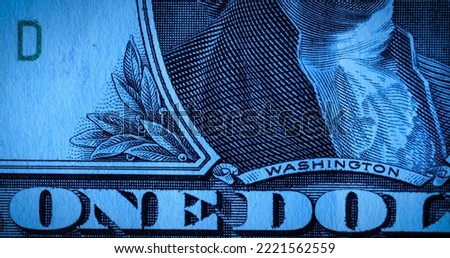 Front side of one dollar paper bill with part portrait of first President George Washington. American dollars banknote in macro shot. American currency, greenback, cash. Money background in blue tint.