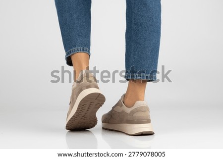 Front, side and rear view of woman's feet in beige and brown sneakers with chunky soles on white background