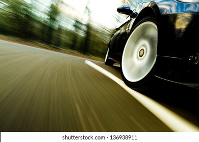 Front Side View Of Black Car Driving Fast.