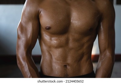 Front side of Young man body with fit and firm muscle,plenty of sweat,blurry light around