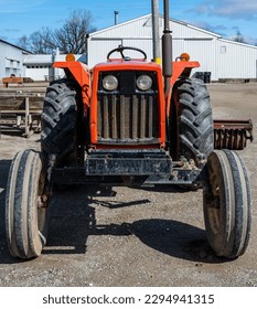Front of a small farm tractor representing machinery commonly used in agricultural operations - Shutterstock ID 2294941315