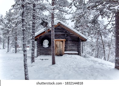 front of snow covered log cabin in the middle of a forest with snowy trees and ground covered in fog - Powered by Shutterstock