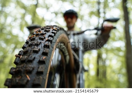 Front tire closeup - Young caucasic man riding a bike, enduro downhill mtb