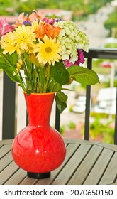 front, top view, close, medium distance of an arrangement of colorful, cut flowers, in full bloom, in an orange vase