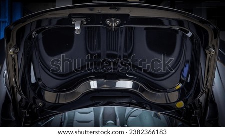 Front trunk of a supercar showing the underside of the hood