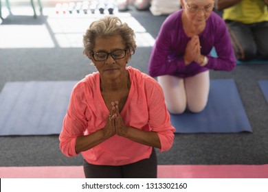 Front view of active senior woman doing yoga in fitness studio