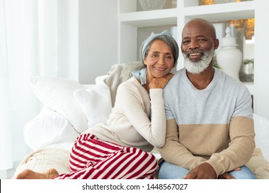 Front View Of African American Couple Sitting In A White Room. Authentic Senior Retired Life Concept