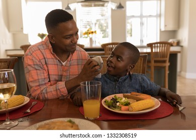 Front view of an African American father wiping sons mouth with napkin after meal on dining table at home. Social distancing and self isolation in quarantine lockdown for Coronavirus Covid19
 - Powered by Shutterstock