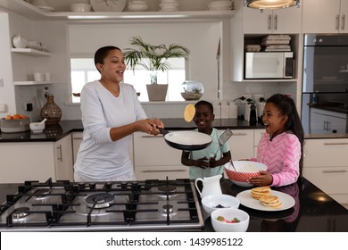Front view of African american Mother and children preparing food on a worktop in kitchen at home. Social distancing and self isolation in quarantine lockdown for Coronavirus Covid19