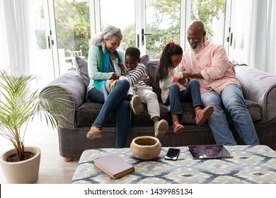 Front view of African american Multi-generation family having fun together on a sofa in living room at home