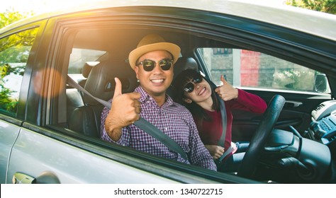 Front View Asian Couple Happiness Sitting In Car Show Thumb Up. Travel Concept, Safety First Insurance Concept