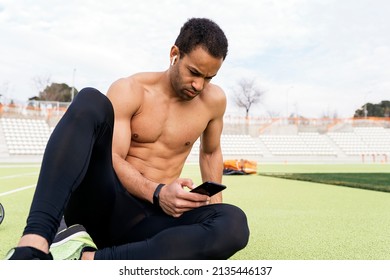 Front View Of An Athlete Using Phone In Athletic Track