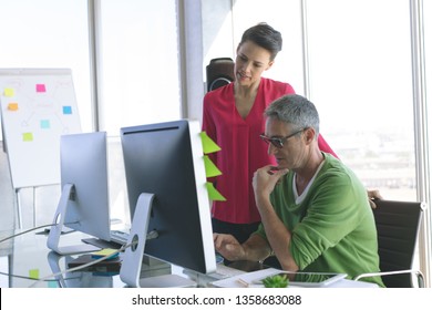 Front view of attentive Multi-ethnic business people working at desk in creative office