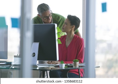 Front view of attentive Multi-ethnic business people working at desk in creative office