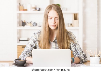 Front View Of Attractive Caucasian Girl Using Laptop In Office With Shleves In The Background