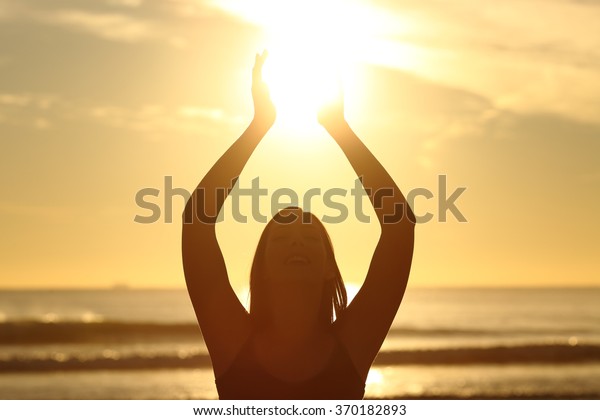 暖かい背景に日の出のビーチに太陽を持つ忠実な女性のバックライトの正面図 の写真素材 今すぐ編集