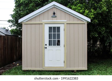 Front View Of A Backyard Tool Shed With A Dog Outside In A Yard. Many Trees Are Surrounding The Shed. DIY Project