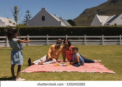 Front View Of Beautiful African American Girl Taking Pictures Of African American Multi-generation Family With Mobile Phone At The Backyard At Home