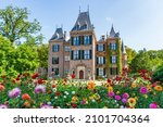 The front view of a beautiful castle with the colorful dahlias in the foreground in a park in Lisse, the Netherlands