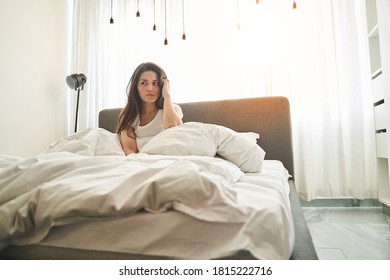 Front view of a beautiful pensive young woman with long dark hair biting her lip - Powered by Shutterstock