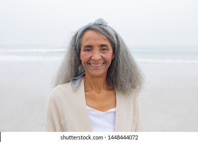 Front view of beautiful senior mixed race woman smiling at the beach. Authentic Senior Retired Life Concept - Powered by Shutterstock