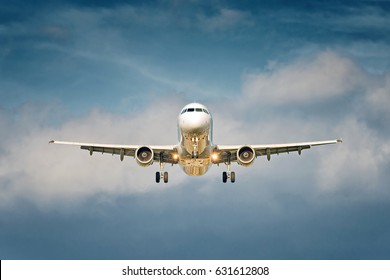 Front View Of A Big Jet Plane Taking Off On Blue Cloudy Sky Background