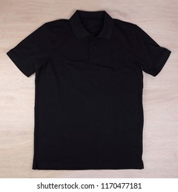 Front view black polo shirt on wooden background - Shutterstock ID 1170477181
